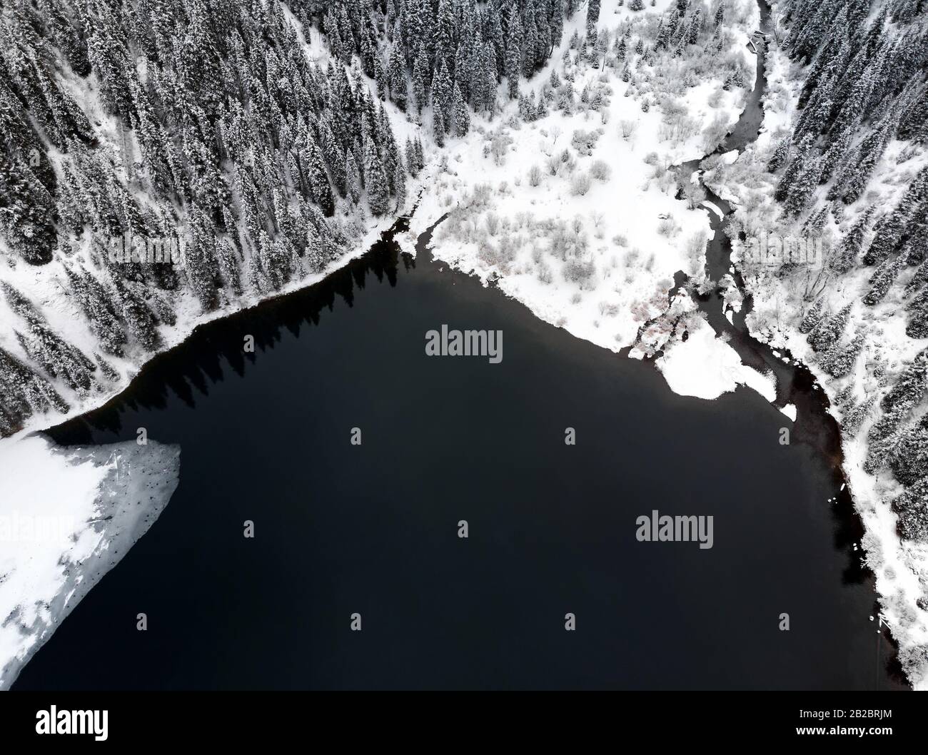 Luftaufnahme von Kolsai-Bergsee und Wald zur Winterzeit in den Bergen von Kazkakhstan. Drohnenschuss, Draufsicht. Stockfoto