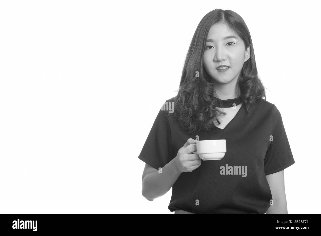 Junge schöne asiatische Geschäftsfrau holding Kaffeetasse Stockfoto