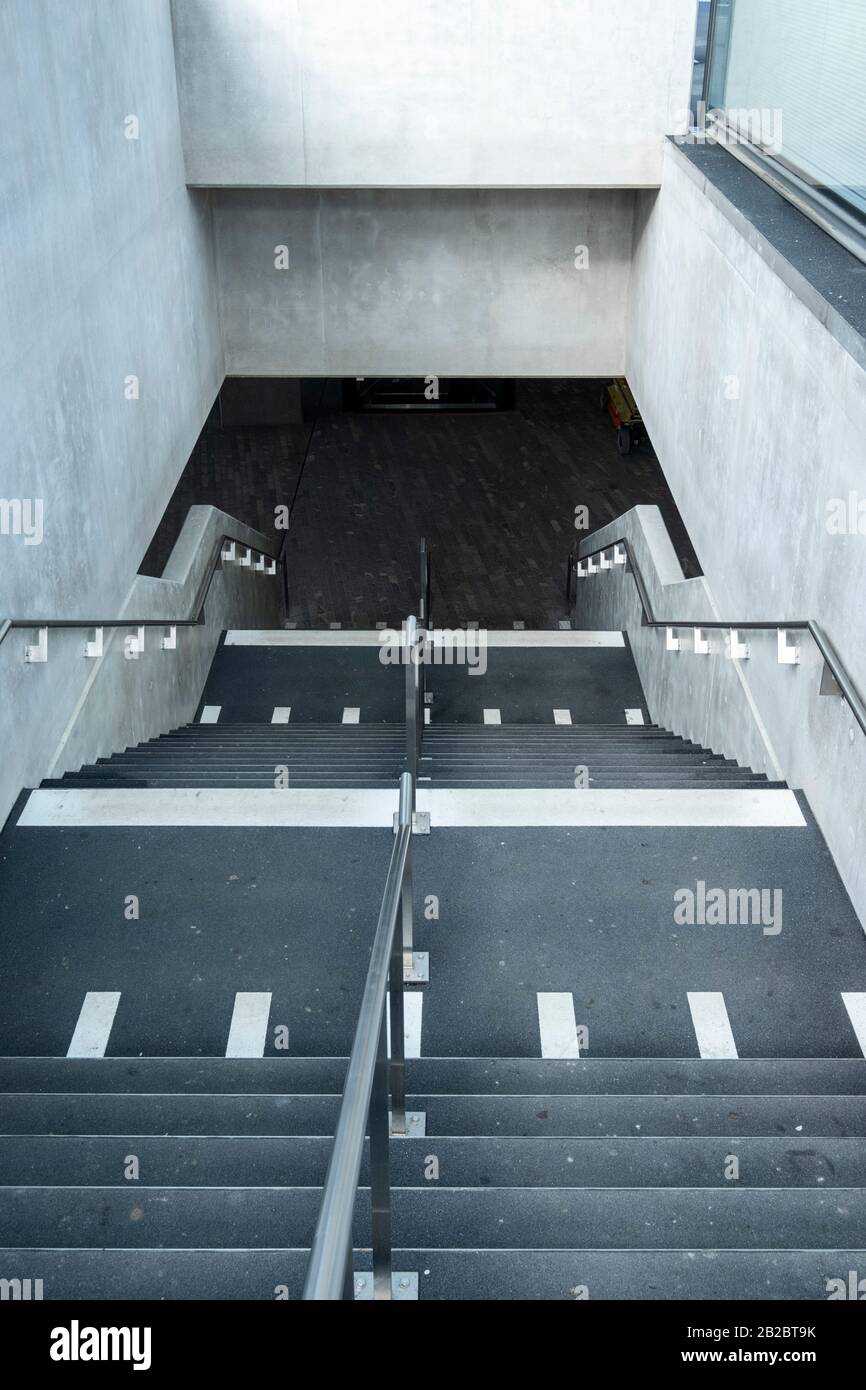 Weiße Markierungen, die auf blinde und sehbehinderte Menschen hinweisen, sind ein Landewechsel auf der Treppe eines Leman-Express-Bahnhofs in Genf, Schweiz Stockfoto