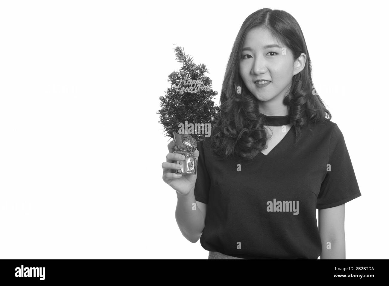 Junge gerne asiatische Geschäftsfrau holding Frohes Neues Jahr Baum Stockfoto