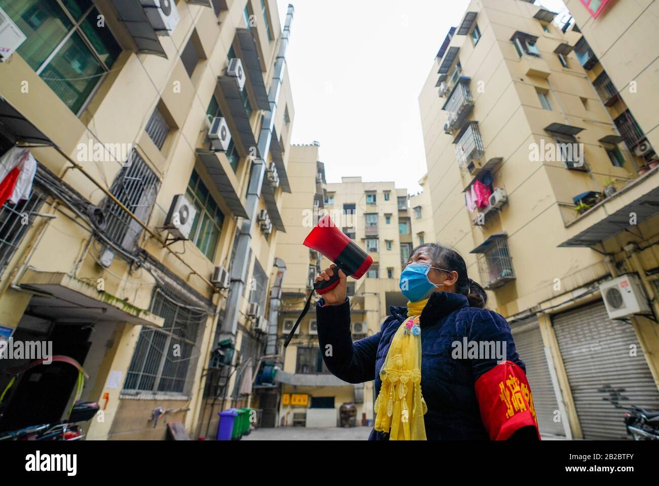 (200302) -- CHONGQING, 2. März 2020 (Xinhua) -- Huang Yuanjun, 62, ein Freiwilliger, stellt den Bewohnern im Beibei-Distrikt im südwestchinesischen Chongqing, 1. März 2020, Gesundheitswissen vor. Insgesamt arbeiten 1.216 Freiwillige in Gebäuden, die sich im Beibei District ohne Immobilienverwaltung zerstreuen. Bei den meisten Freiwilligen mit dem Durchschnittsalter von 58 Jahren handelt es sich um Rentner. Seit dem neuartigen Ausbruch des Coronavirus haben sie sich freiwillig als Wächter gemeldet, um die Informationen der Bewohner zu überprüfen, den Eintritt von Außenstehenden zu stoppen und das Präventions- und Kontrollwissen einzuführen. (Xinhua/Liu Chan) Stockfoto