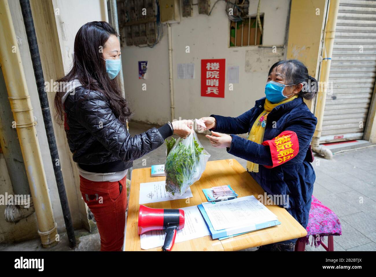 (200302) -- CHONGQING, 2. März 2020 (Xinhua) -- Huang Yuanjun, 62, ein Freiwilliger, ändert die temporäre Eintrittskarte für einen Bewohner in einem Gebäude im Beibei District im Südwesten Chinas Chongqing, 1. März 2020. Insgesamt arbeiten 1.216 Freiwillige in Gebäuden, die sich im Beibei District ohne Immobilienverwaltung zerstreuen. Bei den meisten Freiwilligen mit dem Durchschnittsalter von 58 Jahren handelt es sich um Rentner. Seit dem neuartigen Ausbruch des Coronavirus haben sie sich freiwillig als Wächter gemeldet, um die Informationen der Bewohner zu überprüfen, den Eintritt von Außenstehenden zu stoppen und das Präventions- und Kontrollwissen einzuführen. (Xinhua/Liu Chan) Stockfoto