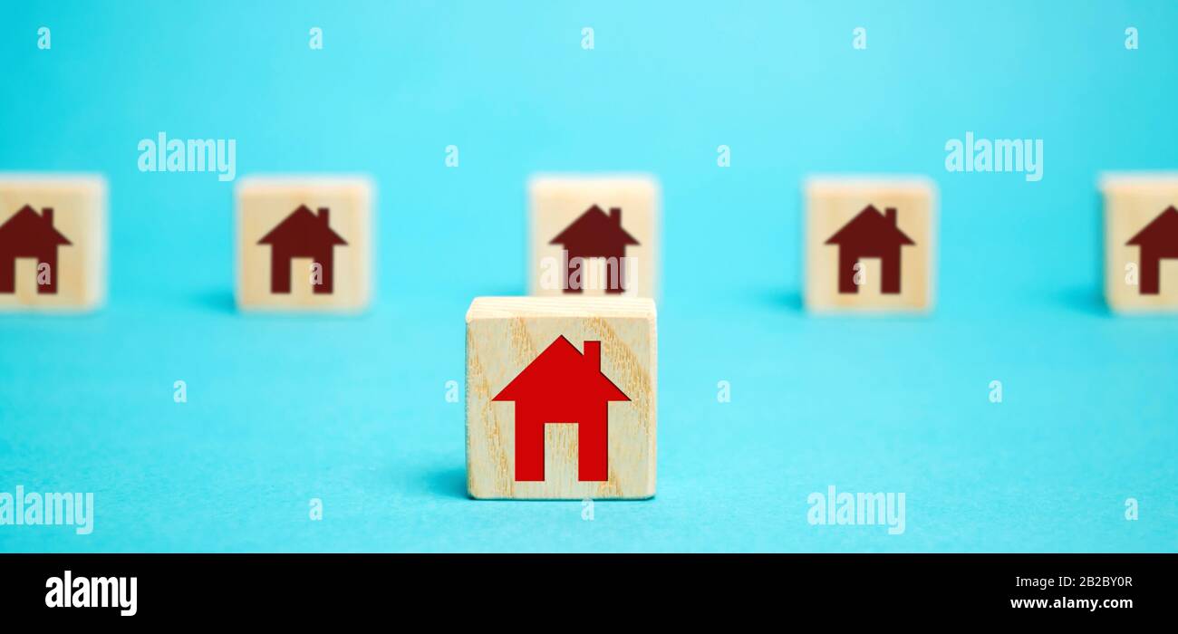 Holzklötze mit einem Bild eines Hauses. Das Konzept, einen Wohnort zu wählen. Beste Auswahl an vorgestellten Optionen. Kauf eines neuen modernen Hauses. Stockfoto