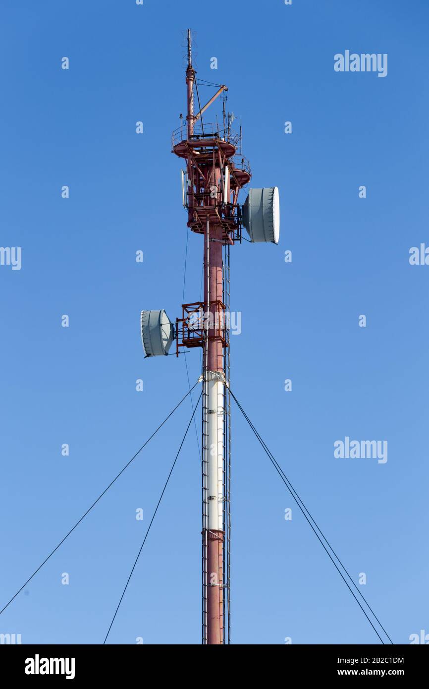 Mast mit Funkrelaisantennen gegen blauen Himmel Stockfoto