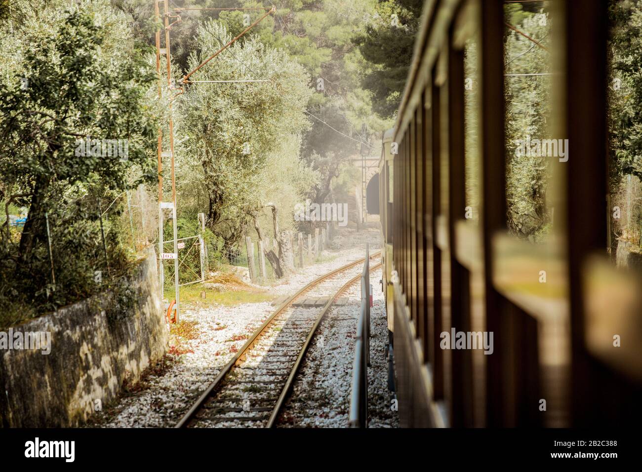 Retro-Holzzug, der auf der Eisenbahn in den Bergen unterwegs ist. Schöne sonnige Sommerlandschaft. Mallorca, Spanien. Stockfoto