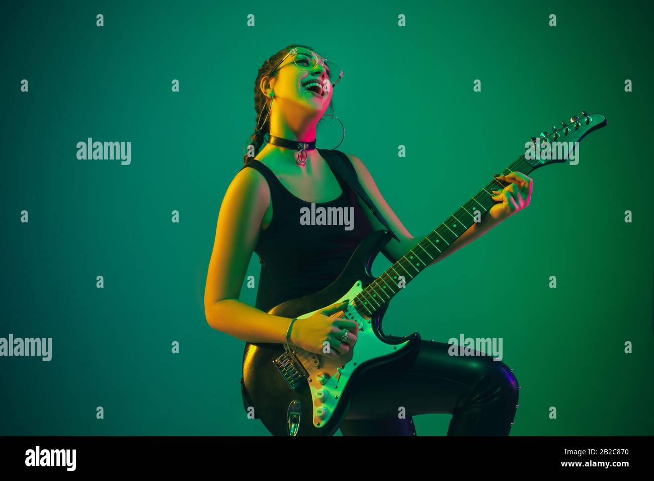 Rockstar Kaukasische Weibliche Gitarrenportrats Auf Grunem Studiohintergrund In Neonlicht Schones Weibliches Modell In Schwarzer Kleidung Mit Gitarre Konzept Menschlicher Emotionen Gesichtsausdruck Werbung Musik Kunst Stockfotografie Alamy