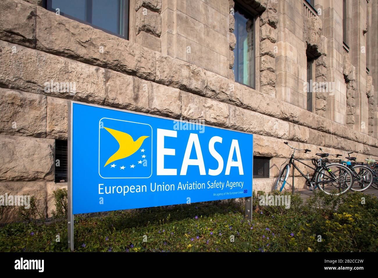 Hinweistafel der Hauptverwaltung der Europäischen Agentur für Flugsicherheit (EASA) vor dem Bürogebäude "neue Leitung" an der Straße Konrad-Adena Stockfoto
