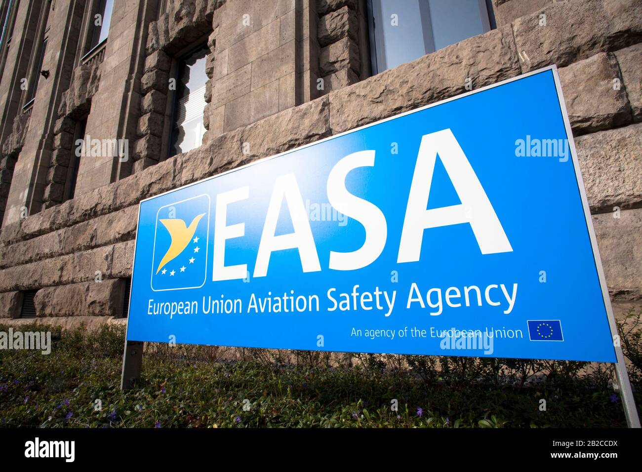 Hinweistafel der Hauptverwaltung der Europäischen Agentur für Flugsicherheit (EASA) vor dem Bürogebäude "neue Leitung" an der Straße Konrad-Adena Stockfoto