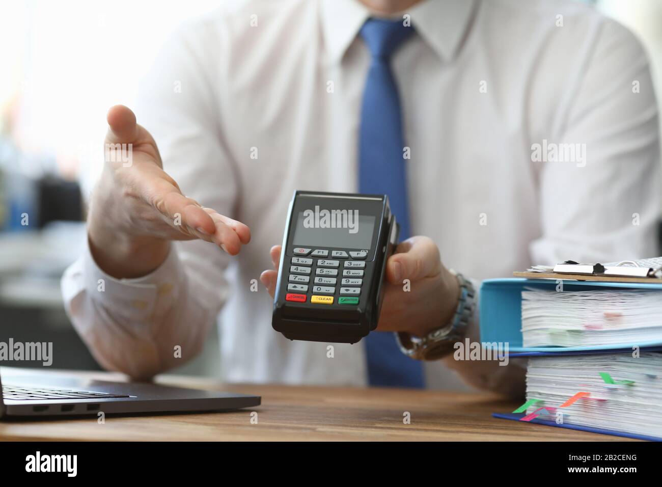 Mann hält sein Hand-Wireless-Terminal gegen Bezahlung Stockfoto