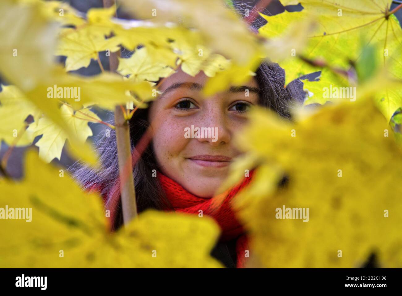Mädchen versteckt in Blättern Stockfoto