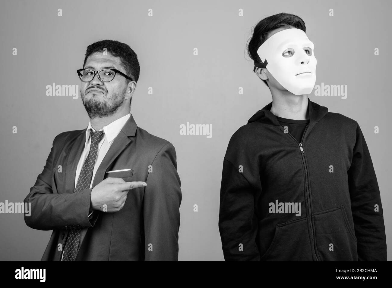 Bärtiger persischer Geschäftsmann und junger Indianermann vor grauem Hintergrund Stockfoto