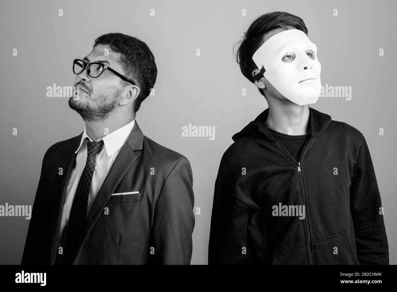 Bärtiger persischer Geschäftsmann und junger Indianermann vor grauem Hintergrund Stockfoto