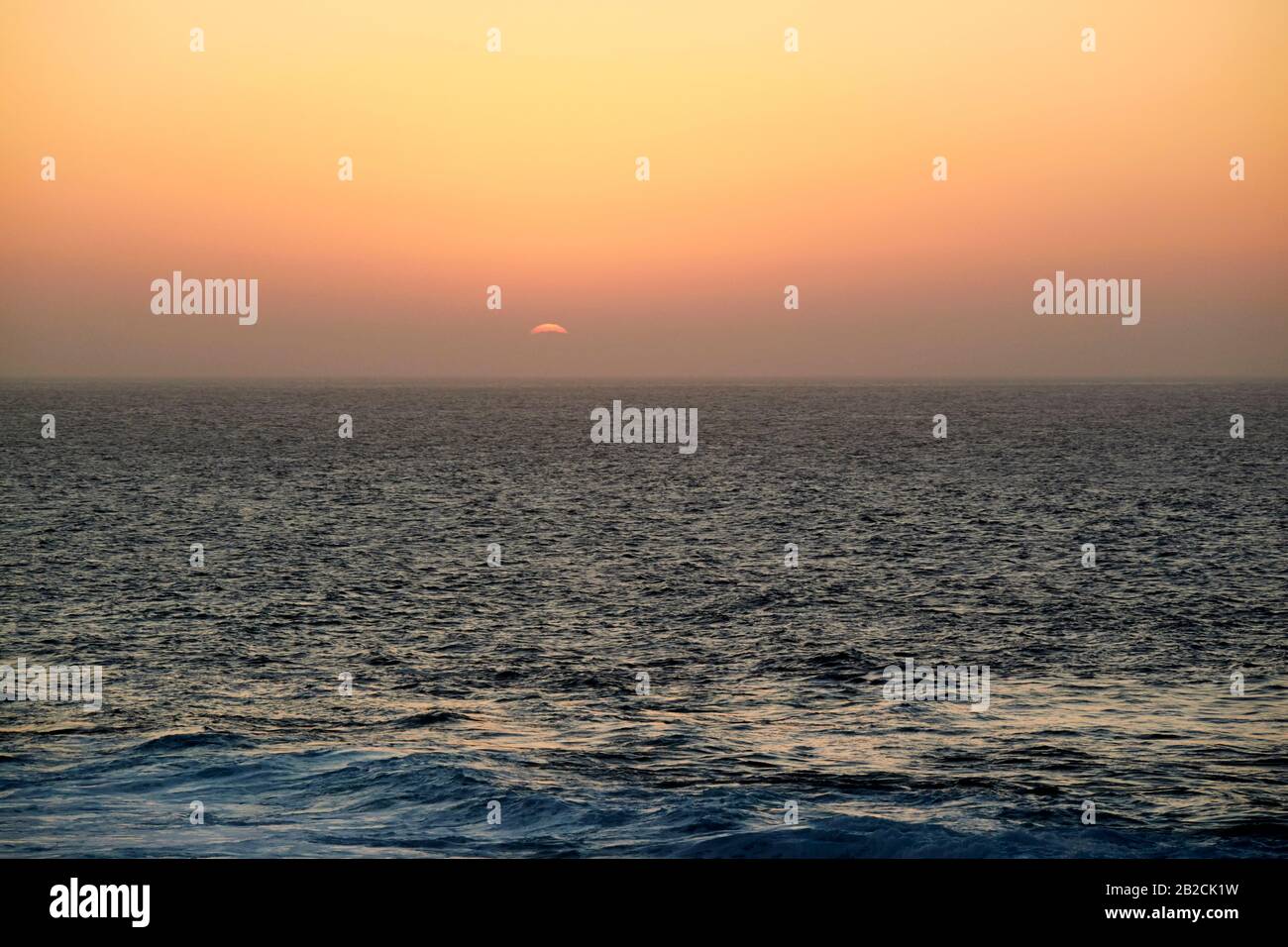 Rote Sonne untergeht am Abend mit rotem Himmel aus sahara-staub, der durch den Kalima-Wind von afrika geblasen wird Lanzarote kanarische Inseln spanien Stockfoto