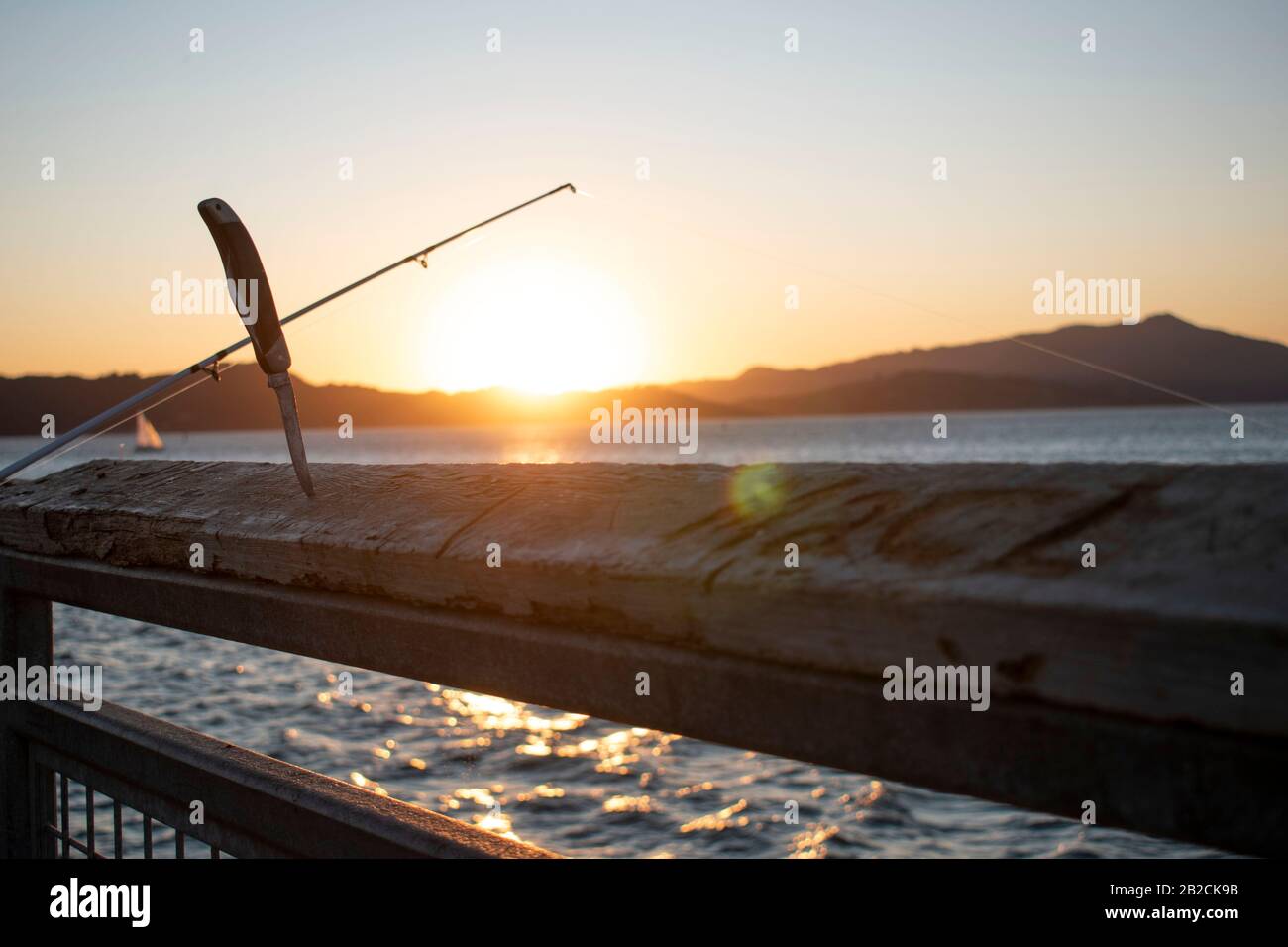 Ein Kehlmesser steht bereit, wenn ein Fischer einen Fisch in Point Richmond, CA fängt. Stockfoto