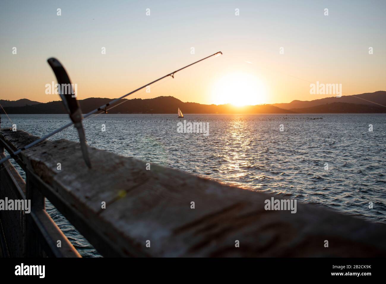 Ein Kehlmesser steht bereit, wenn ein Fischer einen Fisch in Point Richmond, CA fängt. Stockfoto