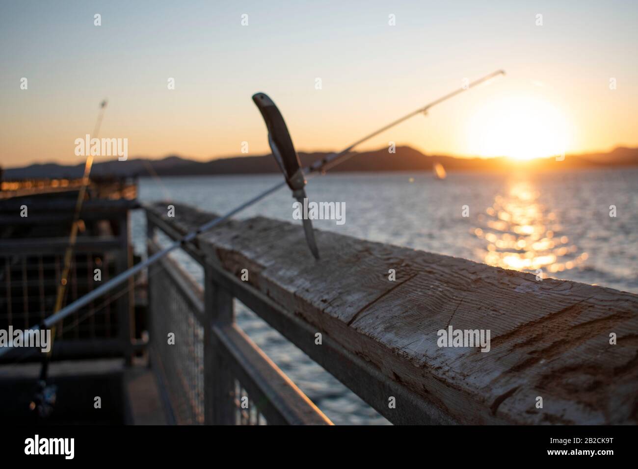 Ein Kehlmesser steht bereit, wenn ein Fischer einen Fisch in Point Richmond, CA fängt. Stockfoto