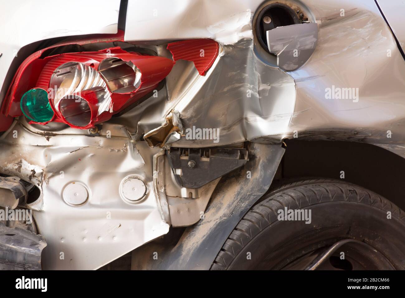 Hinter einem Fahrzeug nach einem Unfall mit mehreren defekten Teilen und mit dem flachen Reifen. Konzept Verkehrssicherheit und Autoversicherung Stockfoto