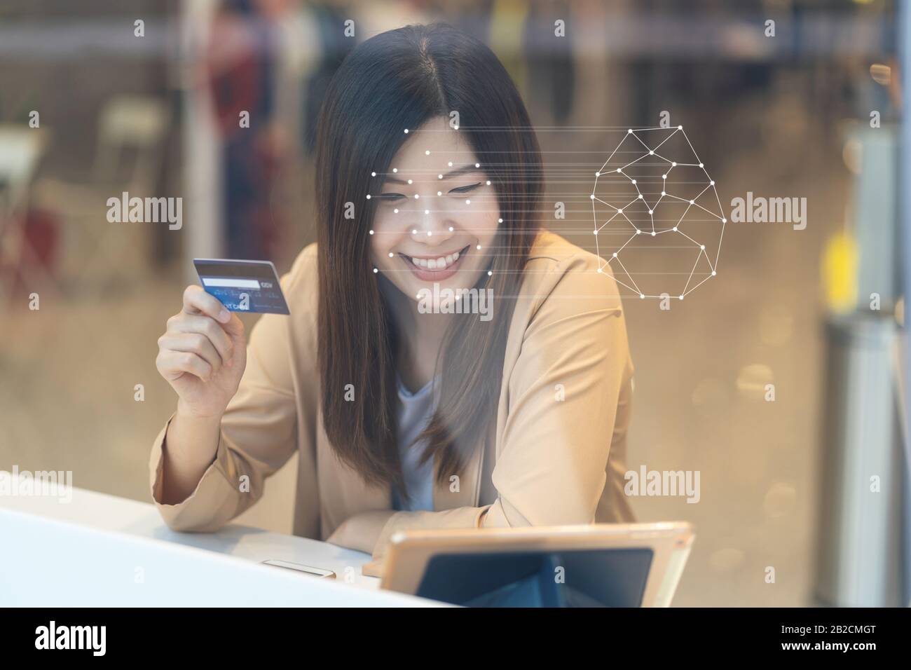 Asiatische Frauen, die das Technologietablett für die Zugriffskontrolle nutzen, indem sie im privaten Identifikationsschritt bei Online-Einkäufen mit dem Kreditauto eine Gesichtserkennung erhalten Stockfoto