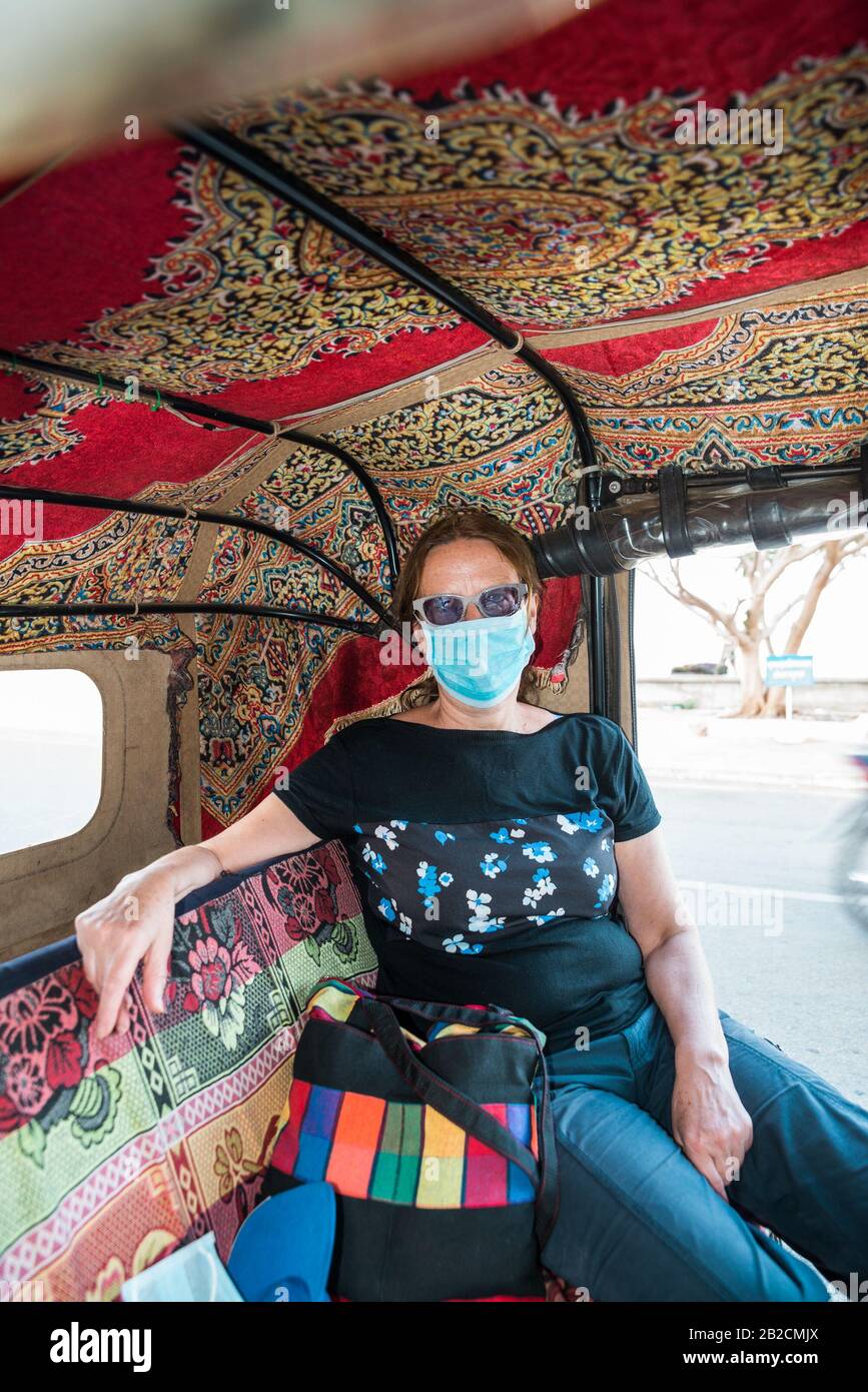 Frau, die in Kratié, Kambodscha, Asien, in einem Tuk-Tuk eine Antivirus-Maske trägt Stockfoto