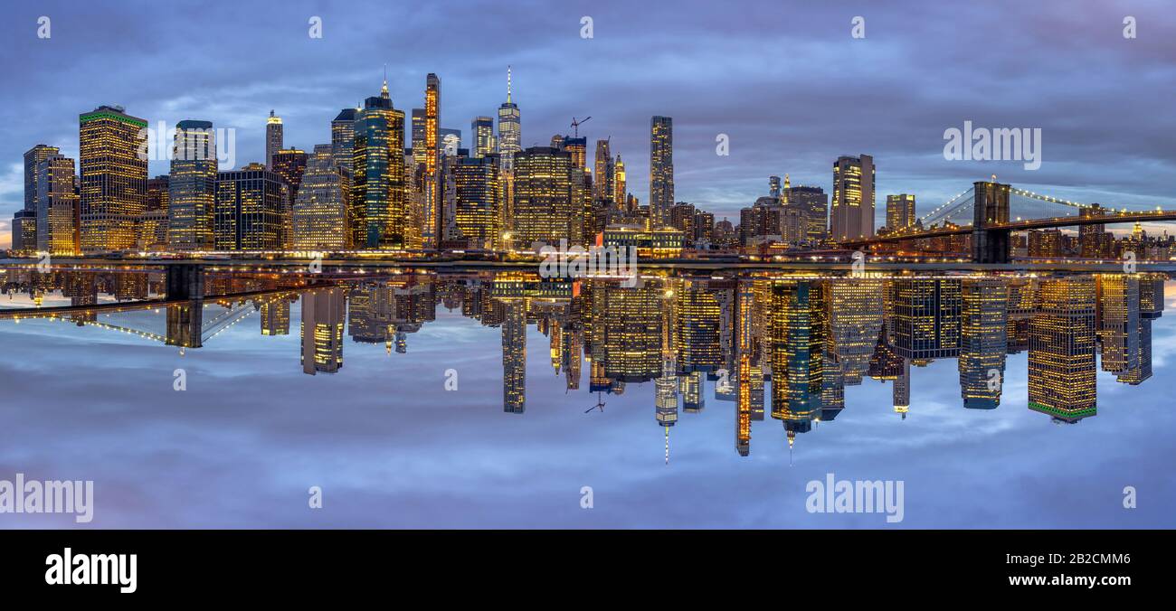 Panoramaszene des New yorker Stadtbildes mit Brooklyn Bridge am Ostfluss zur Dämmerung, Reflexion mit Gegenkonzept, USA Downtown s Stockfoto