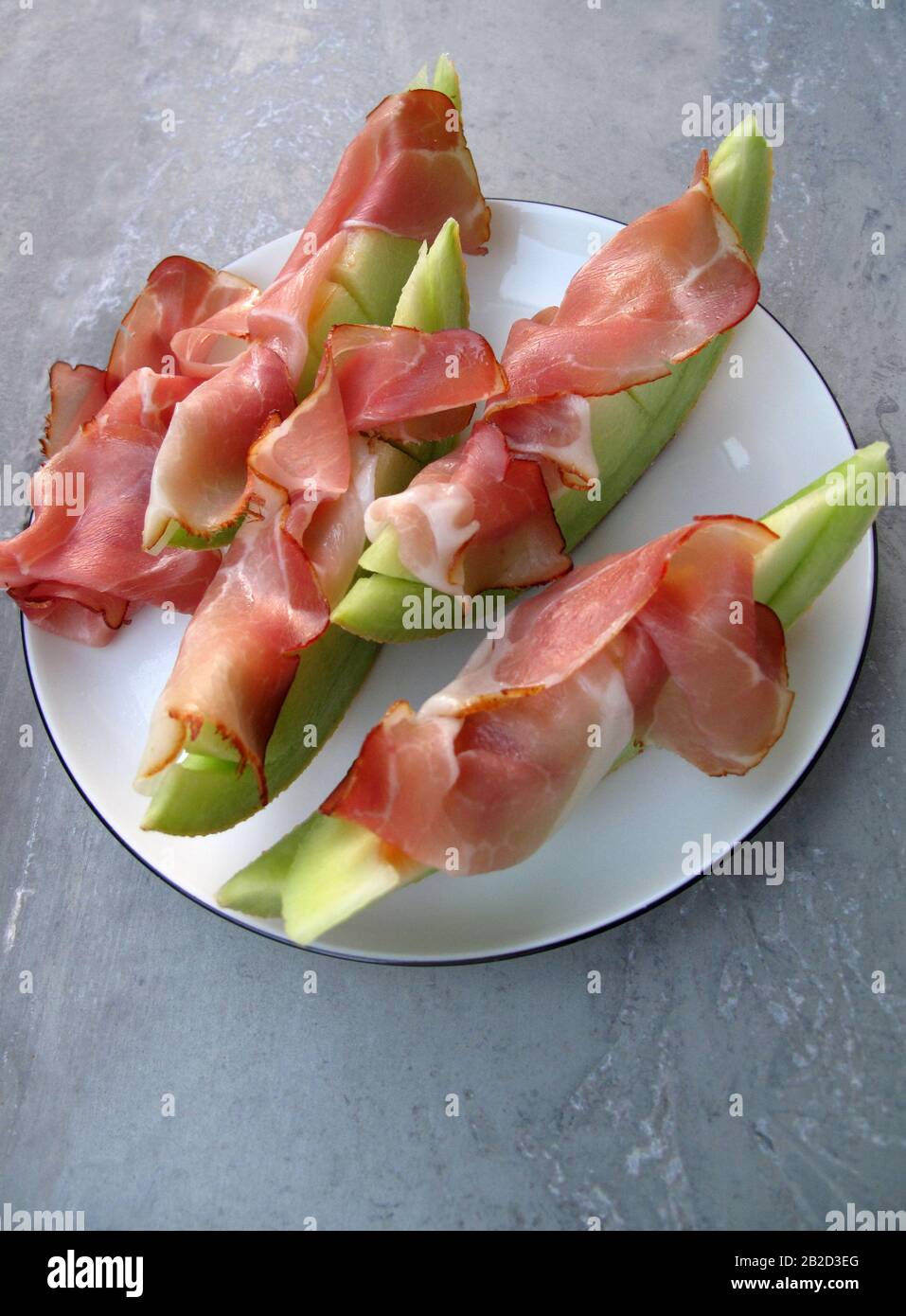 Schinken und Melone auf einem weißen Teller Stockfoto