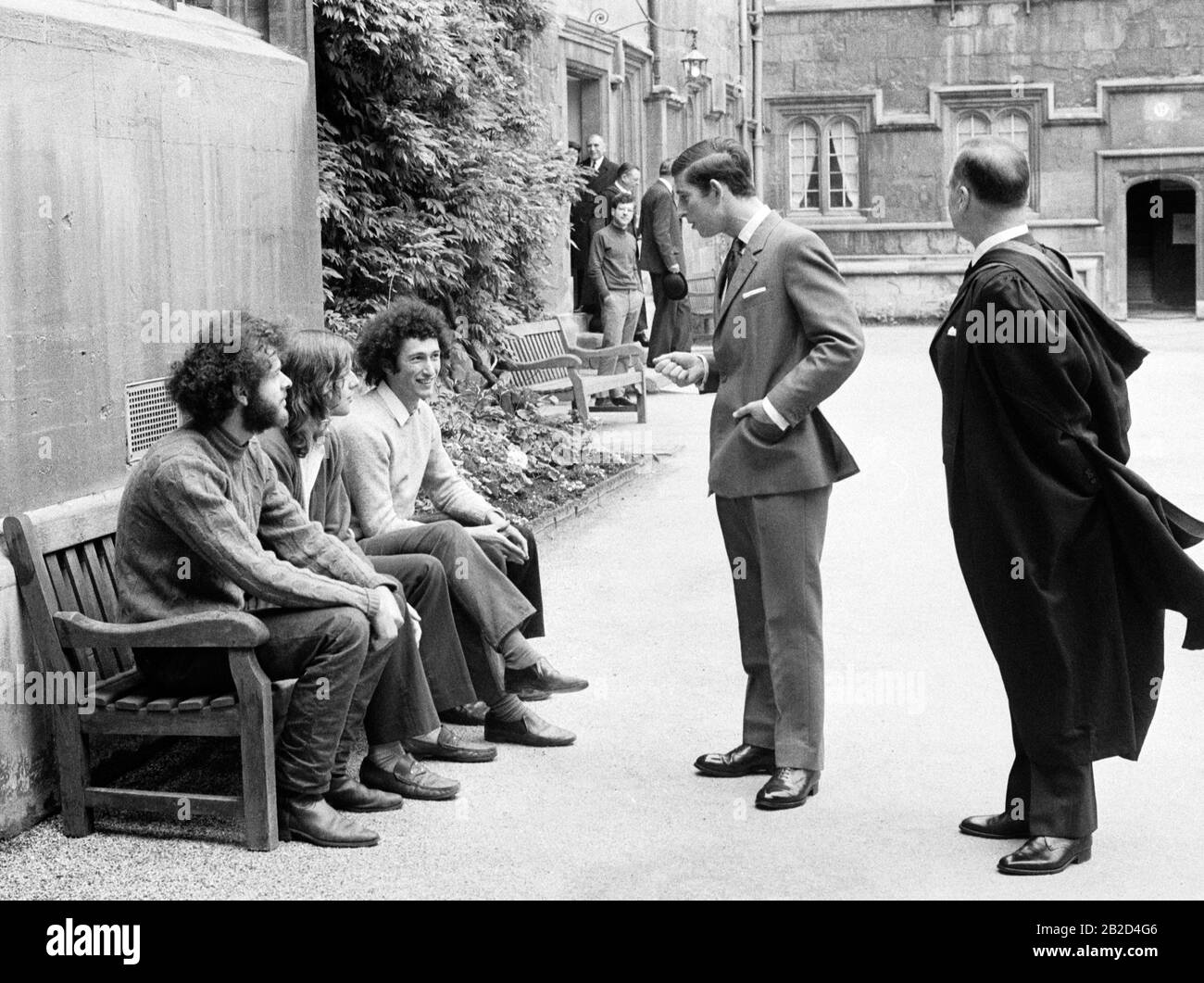 Der Prince of Wales hört auf, mit Studenten zu sprechen, die während seines Besuchs im Jesus College in Oxford eine Bank im Inneren Quad sitzten, wo er das Old Members' Building eröffnete, um das 400-jährige Jubiläum des Colleges zu feiern. Der Neubau kostete etwa 130.000 £und wurde durch einen Appell an alte Mitglieder des College und Fellows finanziert. Stockfoto