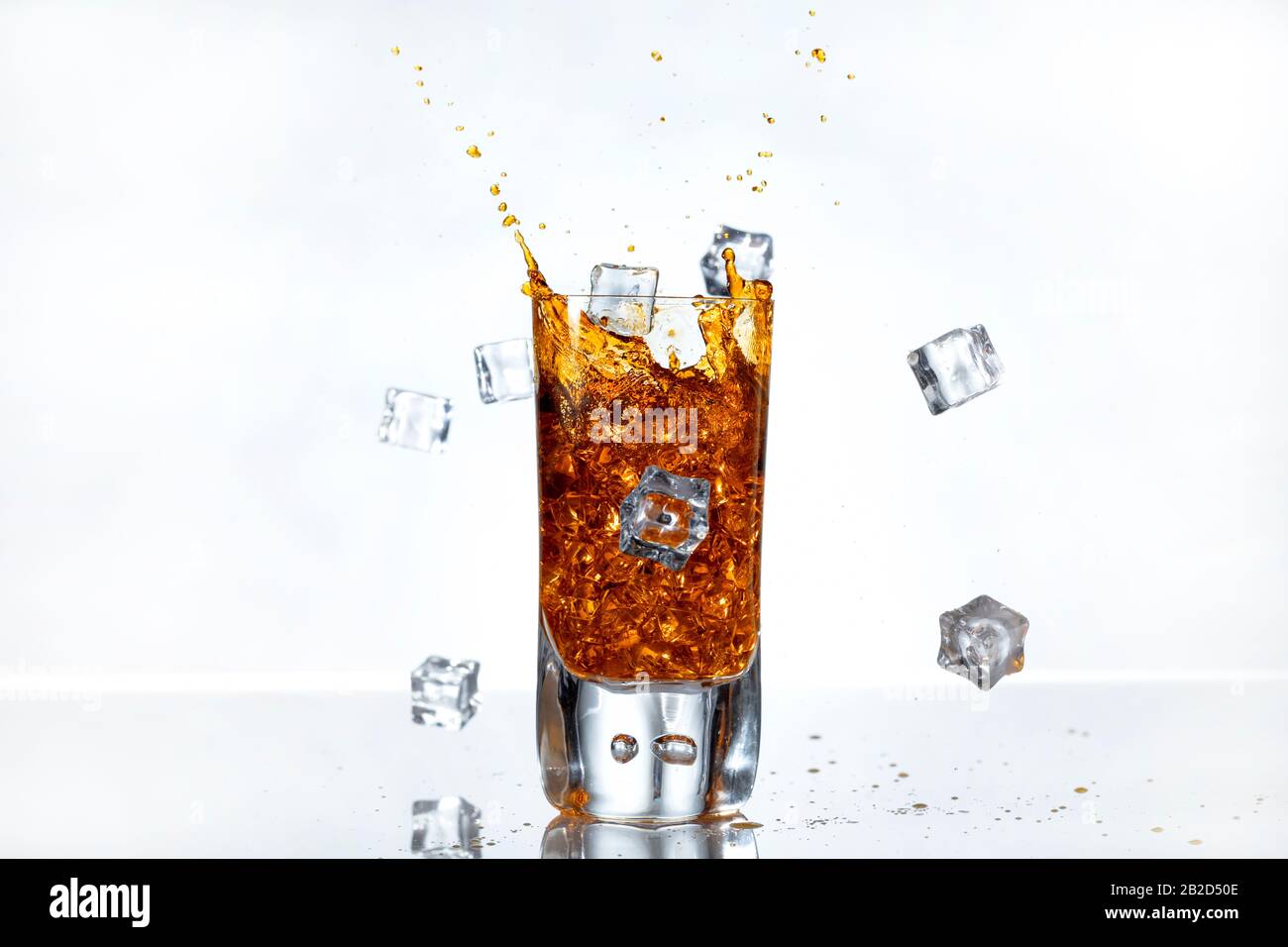 Eiswürfel spritzen in ein Glas Whisky Stockfoto