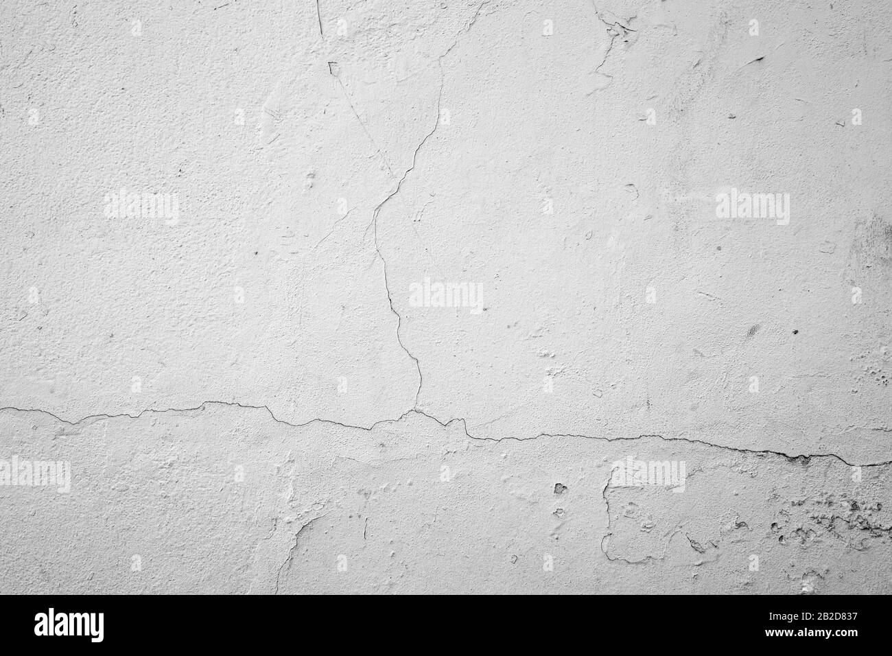 Nahaufnahme eines gerissenen Beton Wand weiß lackiert. Hochauflösende full frame strukturierten Hintergrund in Schwarz und Weiß. Stockfoto