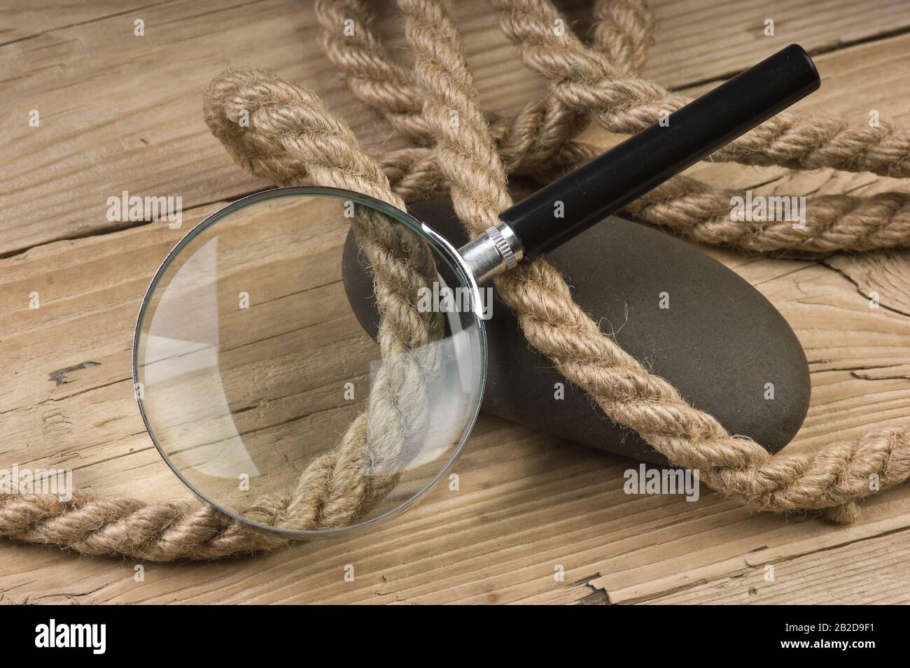 Lupe und Seil auf Holzhintergrund Stockfoto