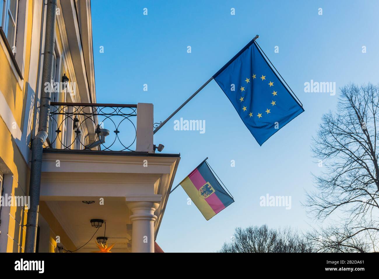 Flagge der EU und Deutschlands auf dem Balkon des Gebäudes gegen den blauen Himmel Stockfoto
