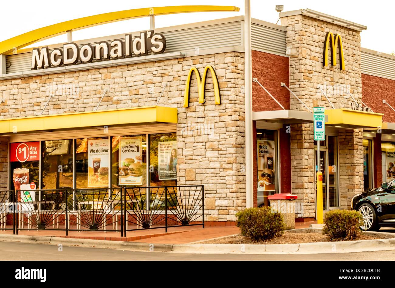 Charlotte, NC/USA - 12. Oktober 2019: Außenfassade aus beigefarbenem Stein von McDonald's, die Marke/Logo in weißen und schwarzen Buchstaben, gelben Bögen und Fenstern zeigt Stockfoto
