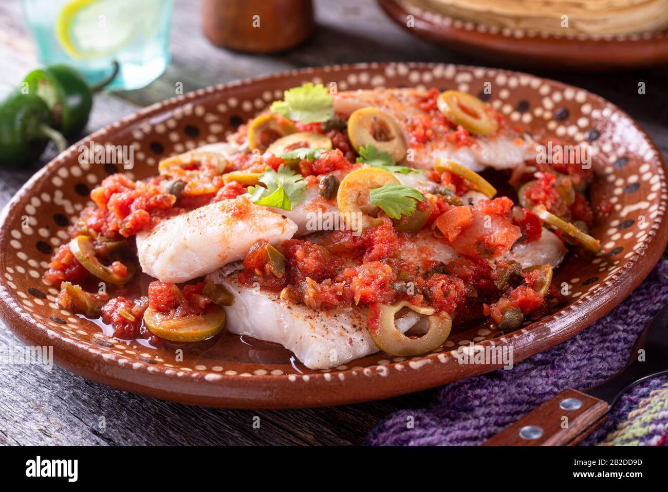 Ein Teller köstlichen fischs veracruz mit Oliven, Tomaten, Zwiebeln, Kapern und Serranopfeffer. Stockfoto