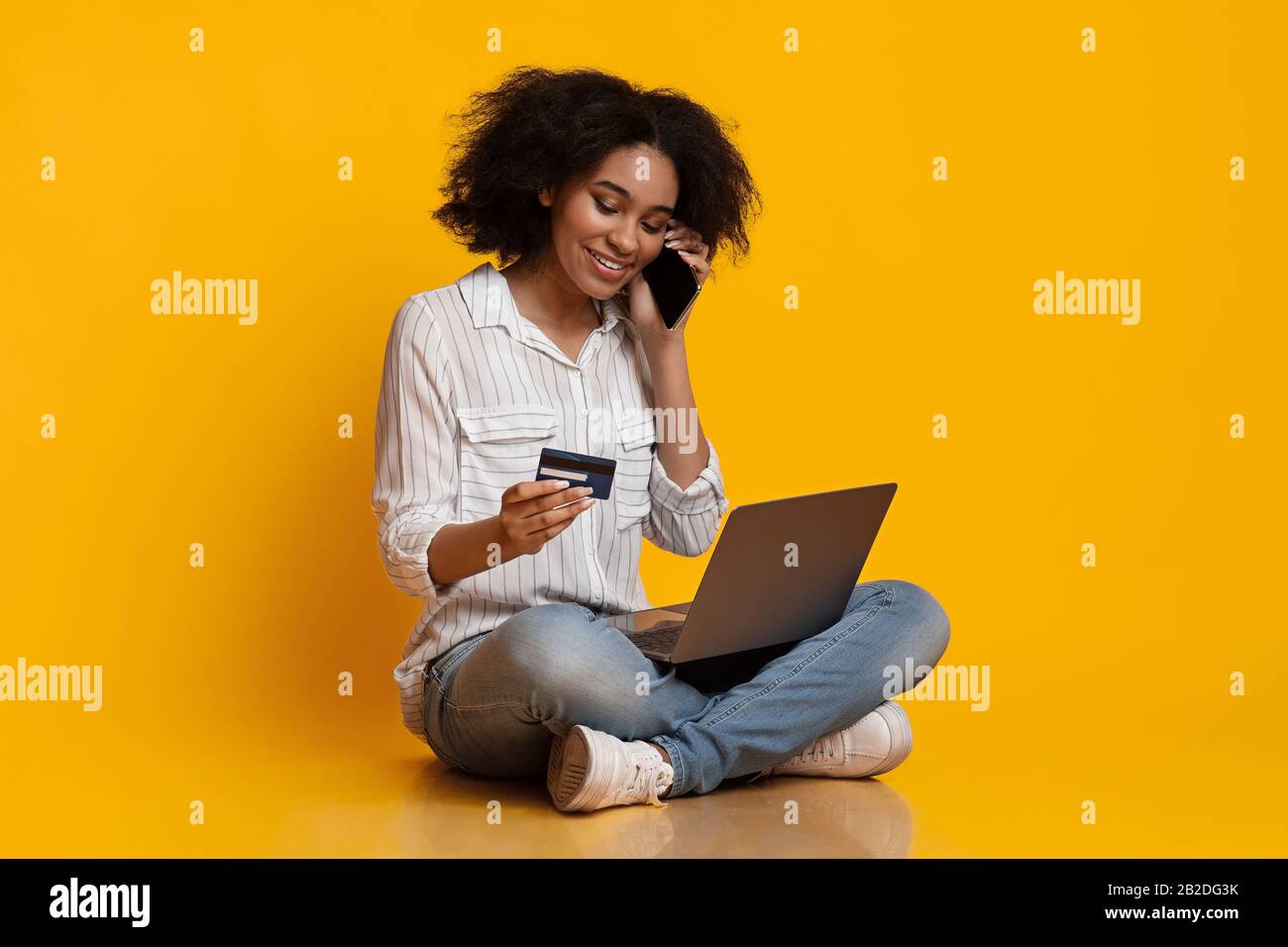 Glückliche afro-Frau mit Kreditkarte und Laptop, telefonieren Stockfoto