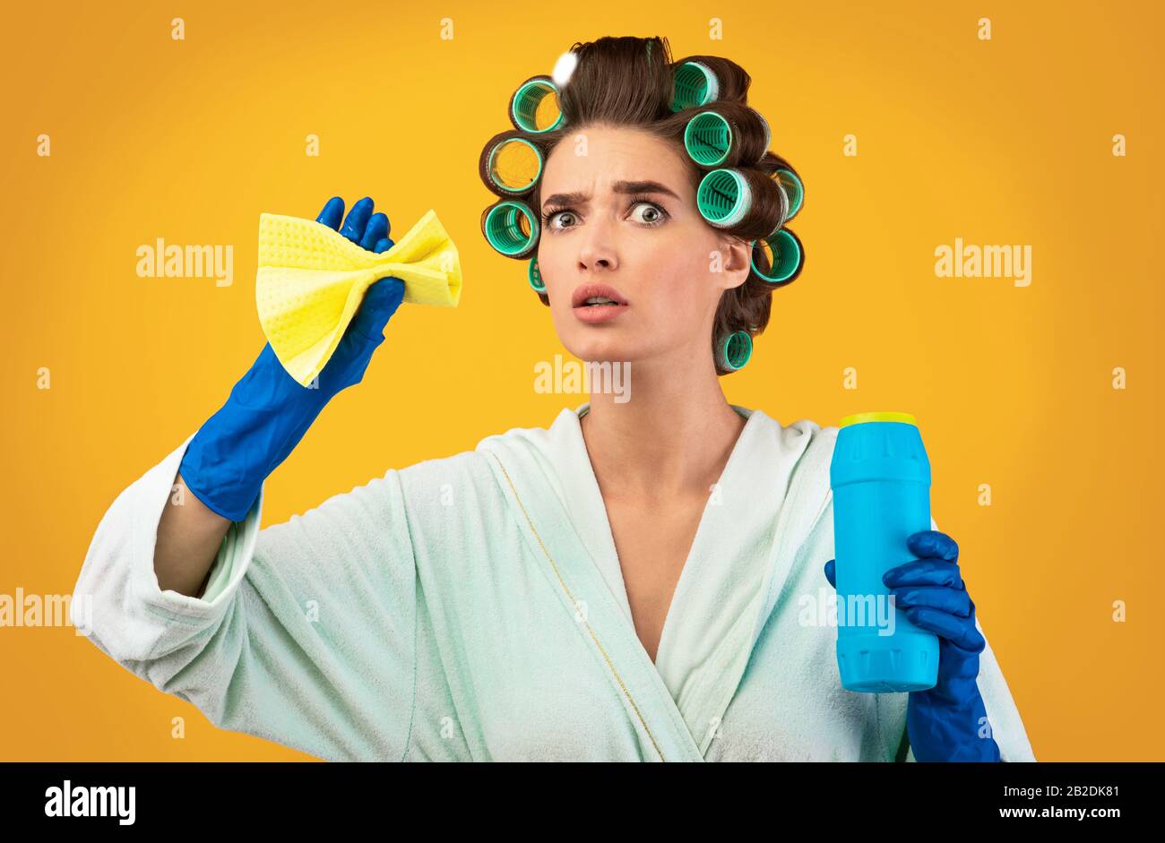 Glamouröse Hausfrau Mit Waschmittelflasche Und Reinigungsschwamm, Gelber Hintergrund Stockfoto