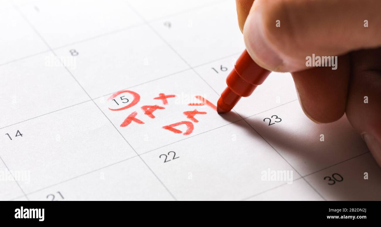 April umkreisen und Steuertag in Rot auf dem Kalender schreiben. Stockfoto