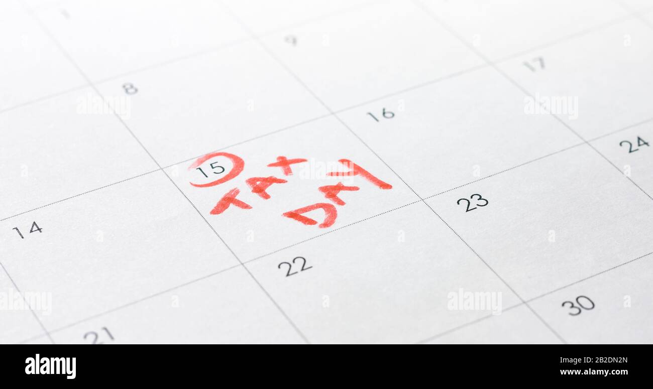April umkreisen und Steuertag in Rot auf dem Kalender schreiben. Stockfoto