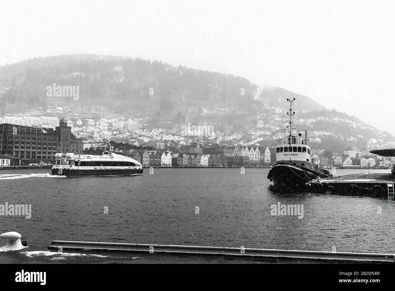 Winter in Bergen, Norwegen. Stark schneit. Blick vom alten Hafen der Stadt, Vaagen. Hanseatische Architektur der UNESCO in Bryggen. Veteran Schleppboot Vulc Stockfoto