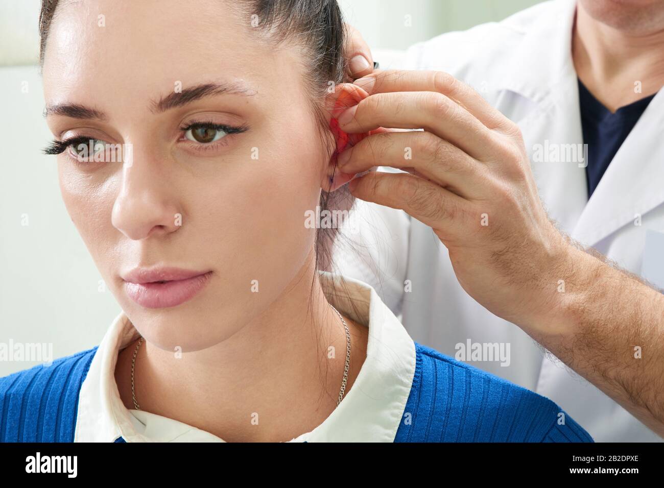 Der plastische Chirurg untersucht das Ohr des Patienten vor einer plastischen Operation Stockfoto