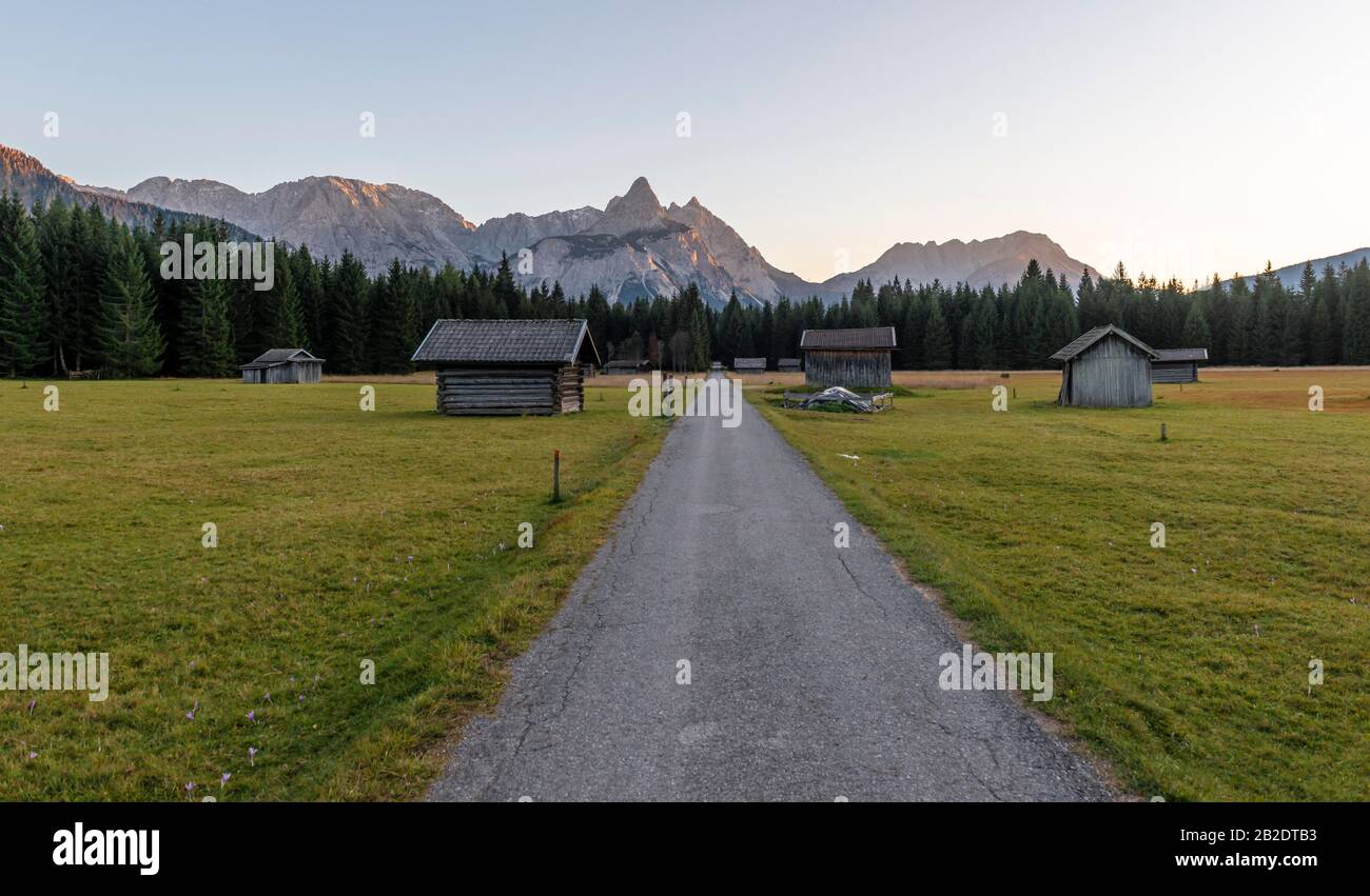 Wiese mit Heustadln, hinter Mieminger Kette mit Ehrwalder Sonnenspitze, Wetterstein Range, Werdenfelser Land, Oberbayern, Bayern, Deutschland Stockfoto