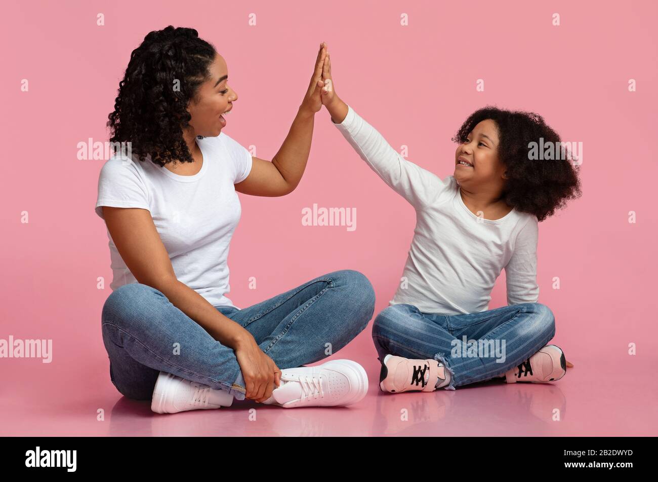 Happy Black Mama Und Tochter, Die Sich Gegenseitig Hohe Fünf Geben Stockfoto