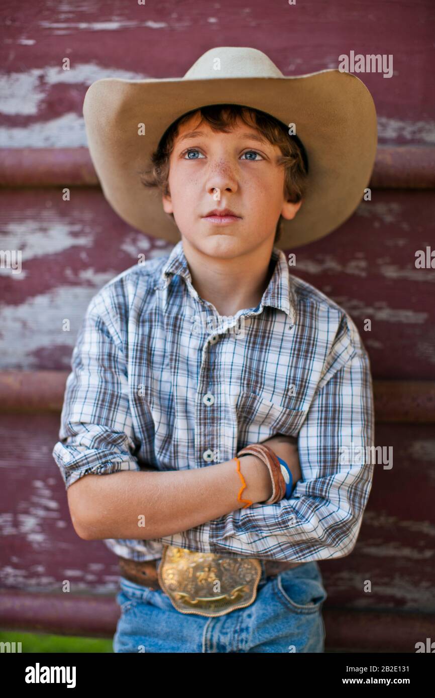 Porträt eines jungen Jungen in Westernbekleidung auf einer Ranch Stockfoto