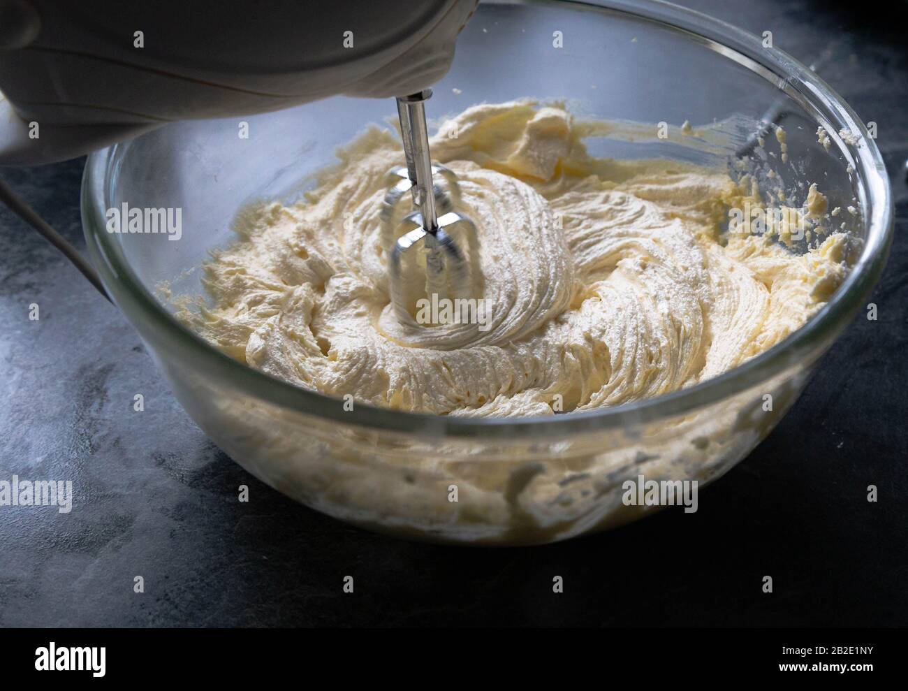 Eine Schüssel Butter und Zucker, die zusammen mit einem Handschwirl gecremt werden. Stockfoto