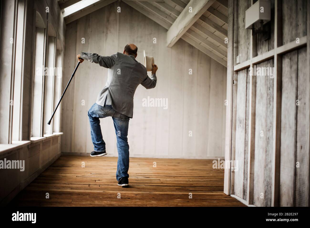Mann mittleren Alters tanzt mit einem Stock Stockfoto