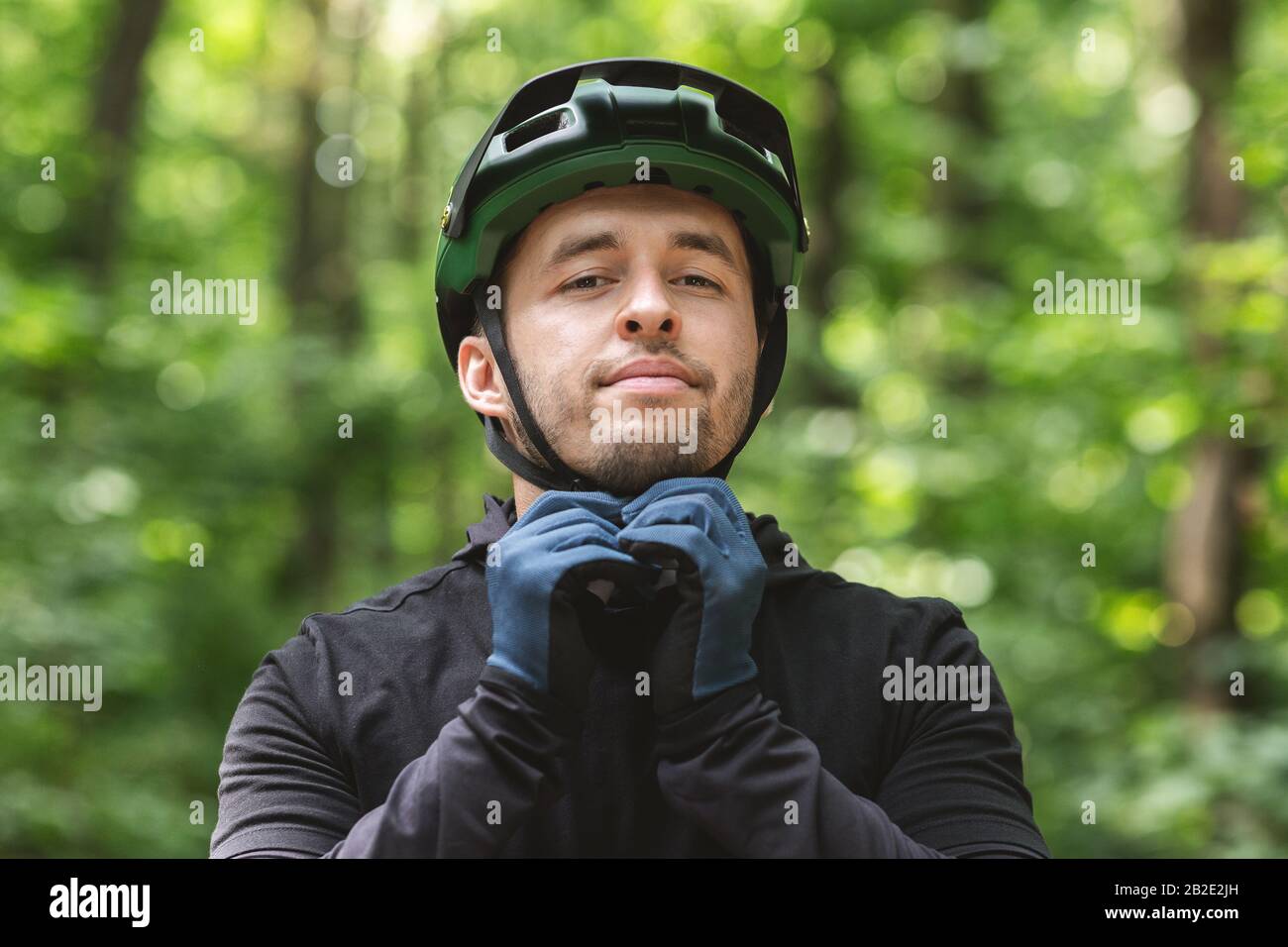 Junge Sportlerin trägt Helm über Waldhintergrund Stockfoto