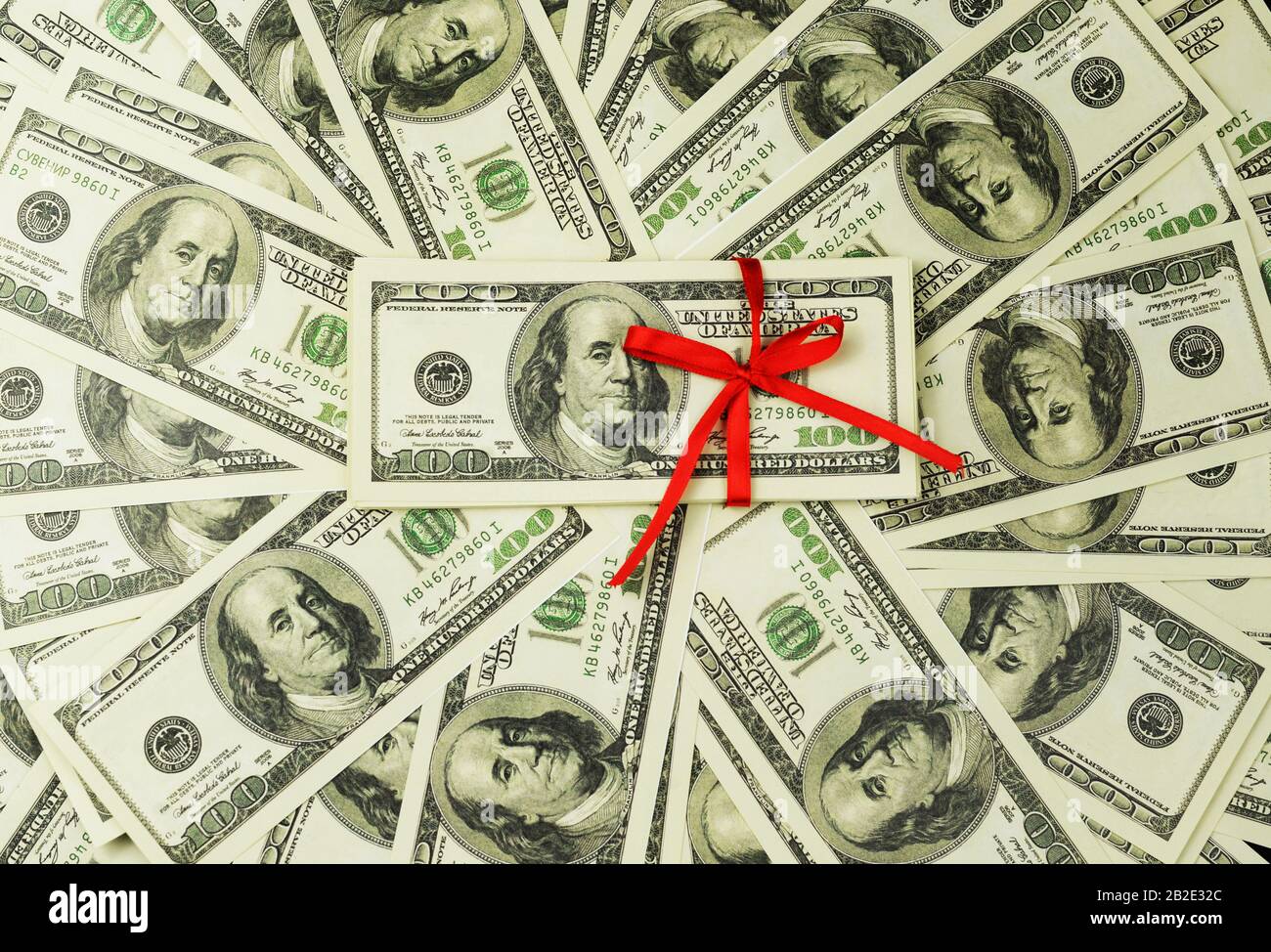 Hintergrund einer Menge Geldscheine 100 Dollar kanadischen Amerikaner in einem Stapel mit rotem Bogen, der eine Lotterie mit einem Geschenkgeschenk gewinnt Stockfoto