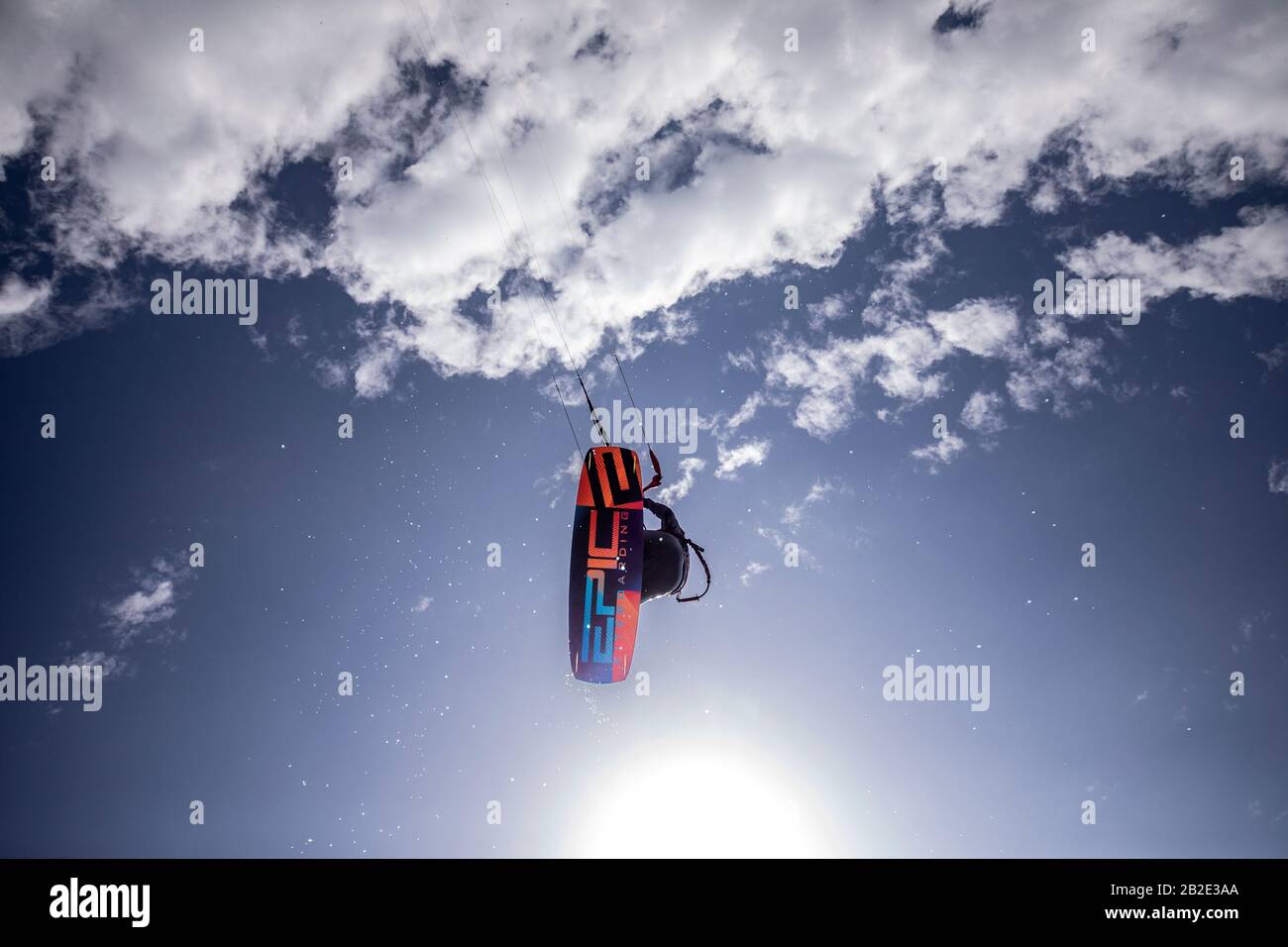 Kiteboarder Dimitri Maramenides macht aus einem sauberen Sprung Tricks in der Luft über den Kopf. Stockfoto