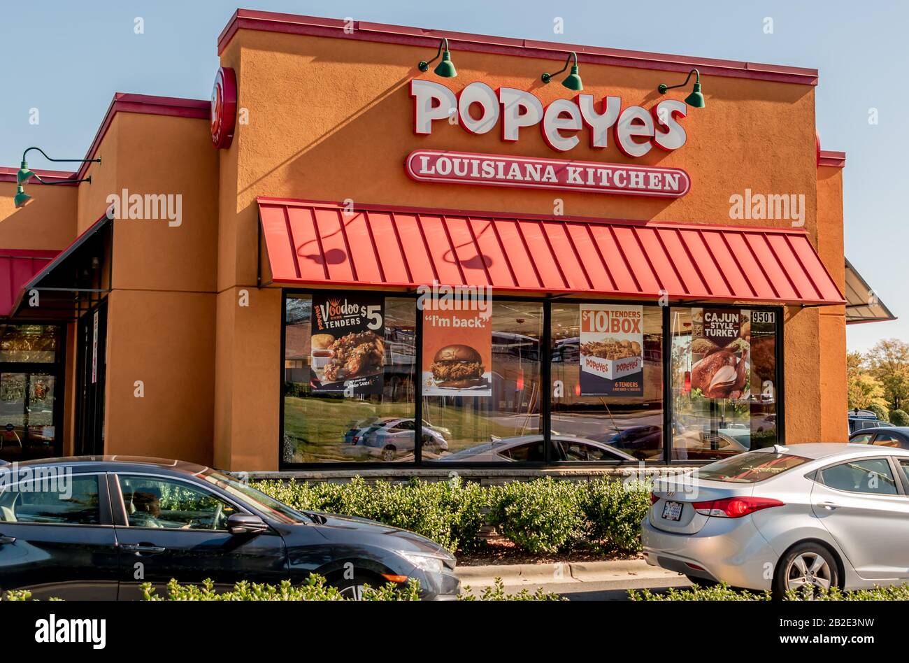 Charlotte, NC/USA - Novenber 9, 2019: Mittlerer Außenschuss der Marke "Popeyes Louisiana Kitchen" in Rot und Weiß an der Fassade des Gebäudes mit Markise Stockfoto