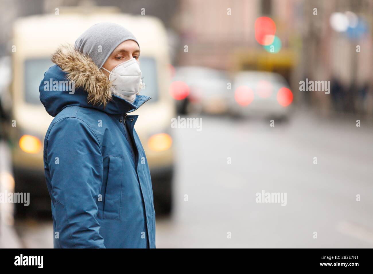 Der Kranke auf öffentlichen Verkehrsmitteln hält an, trägt eine Gesichtsmaske gegen übertragbare Infektionskrankheiten und als Schutz gegen die Grippe oder coron Stockfoto