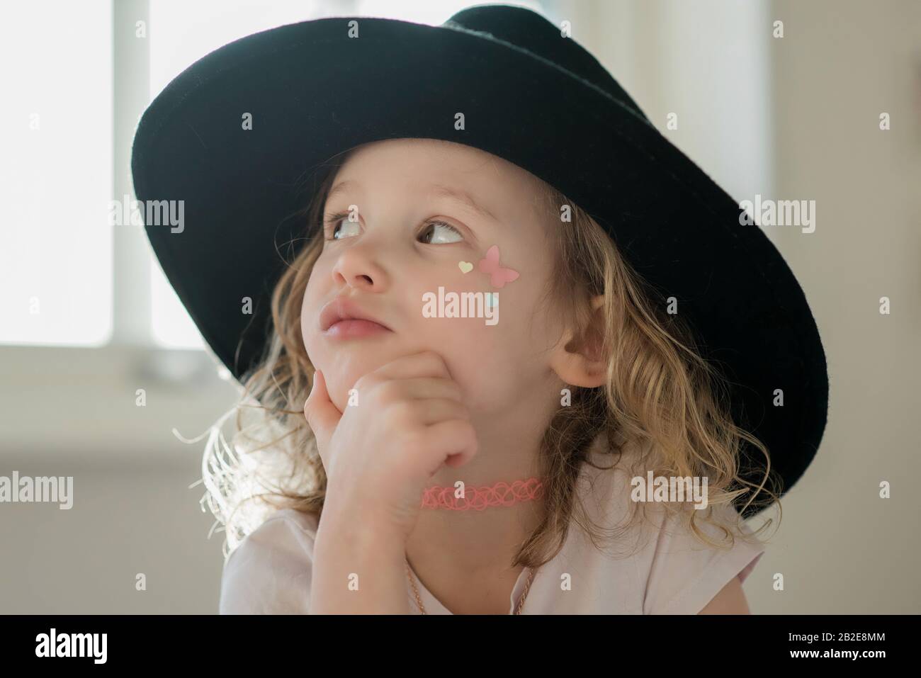 Porträt eines jungen Mädchens mit ihrem Gesicht bemalt und Phantasie Kleid Hut Stockfoto