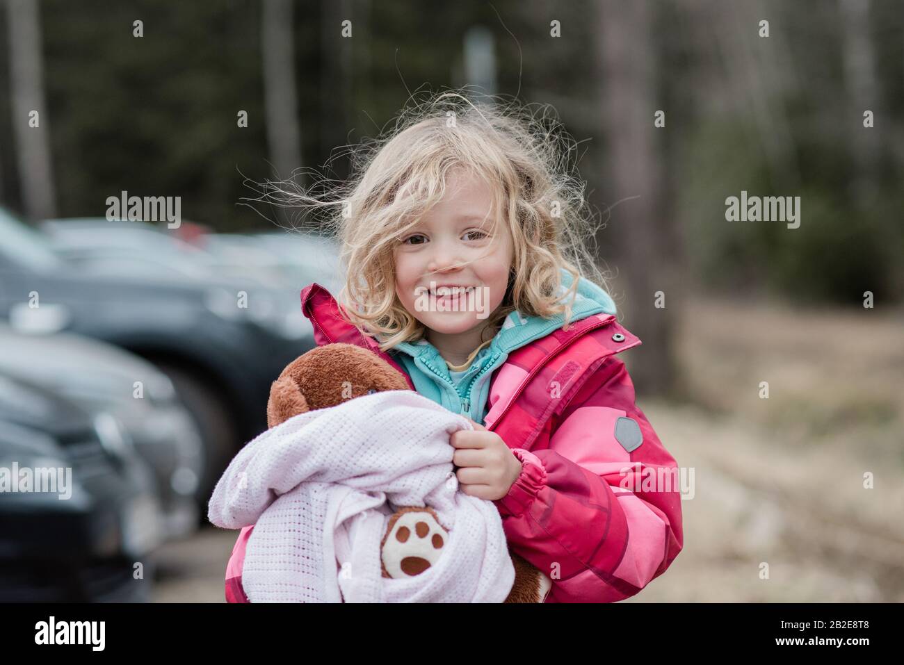 Ehrliches Porträt eines jungen Mädchens, das mit unordentlichen Haaren lächelt Stockfoto